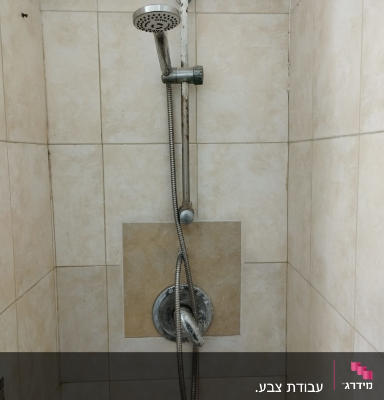 מקלחת עם ראש טוש מתכת על קיר אריחים